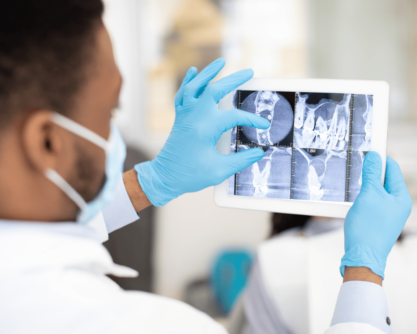 African American Male Dentist Doctor Using Digital Tablet, Checking Patient's Teeth Xray Picture While Working In Modern Dental Clinic, Professional Stomatologist Checking Treatment Result, Closeup